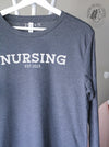 Collegiate: "Nursing est. 2023" on Heather Navy long sleeve