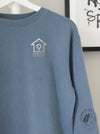 Slate Blue sweatshirt with a silver coloured logo on the front of the shirt (mock up)
